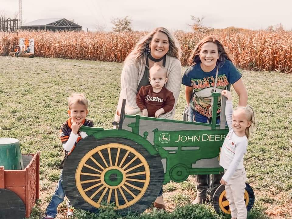 Famiy posing for photo at a prop tractor