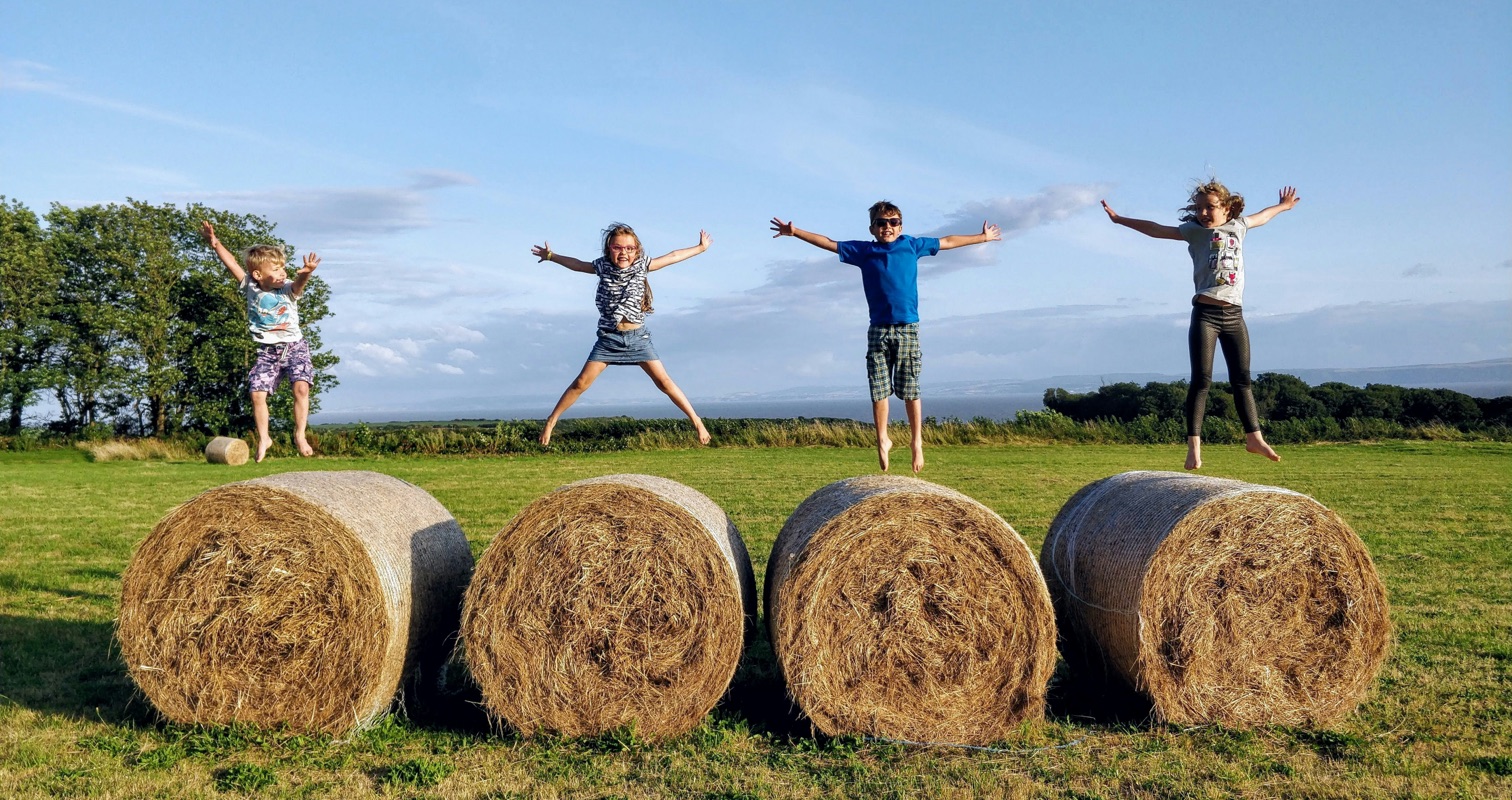 kids jumping on hay